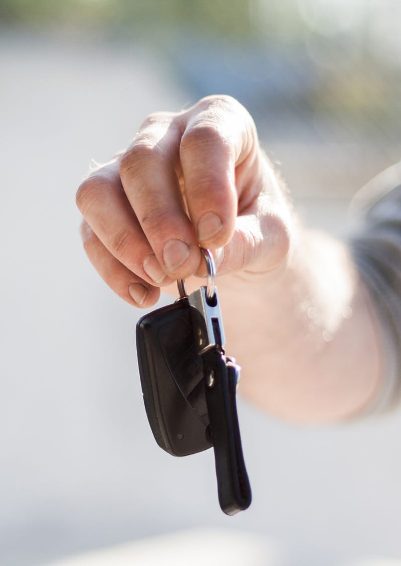 En hand räcker över en bilnyckel
